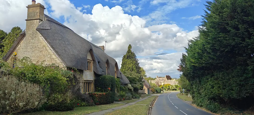 Thatched cottages along a Cotswolds lane