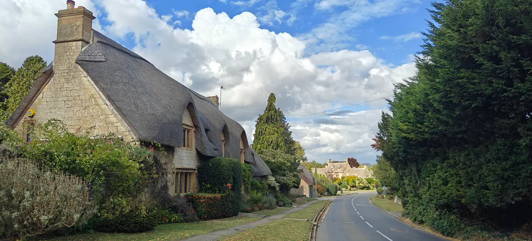 Thatched cottages along a Cotswolds lane