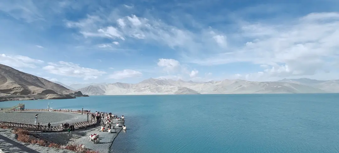 Pale sand mountains across the turquoise waters of Baisha Lake
