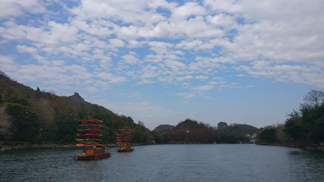 Red-sailed wooden boats on a karst-ringed lake, Guilin