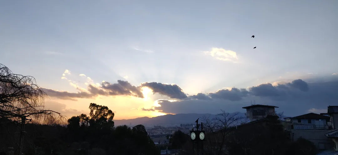 Sun rays breaking over the Kyoto basin at dusk
