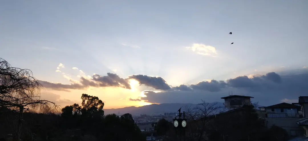 Sun rays breaking over the Kyoto basin at dusk